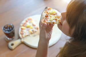 Woman Eating Tasty Pizza in great restaurants in independence