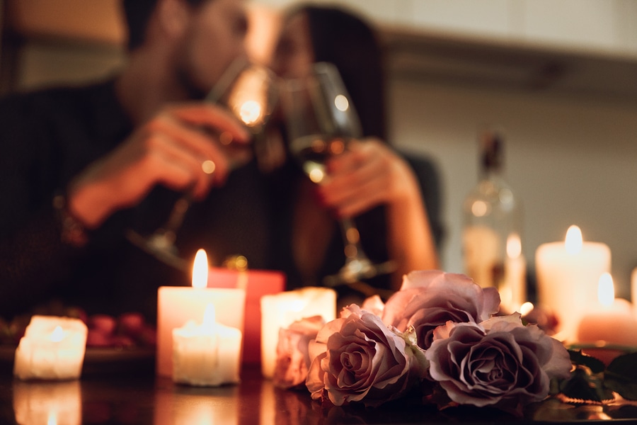 Couple toast with wine in front of candlelight dinner on a Romantic Bed and Breakfast getaway