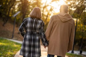 Couple holding hands and walking in park during a Romantic Bed and Breakfast getaway