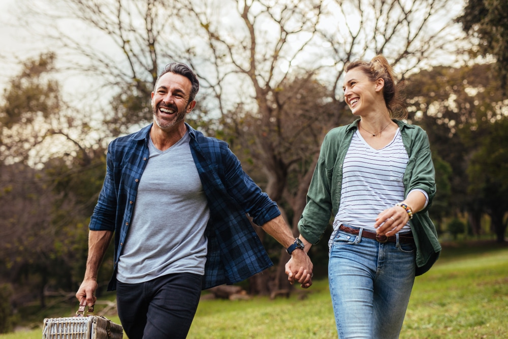 A couple holds hands on a walk in Independence MO on their secluded romantic getaways in Missouri.