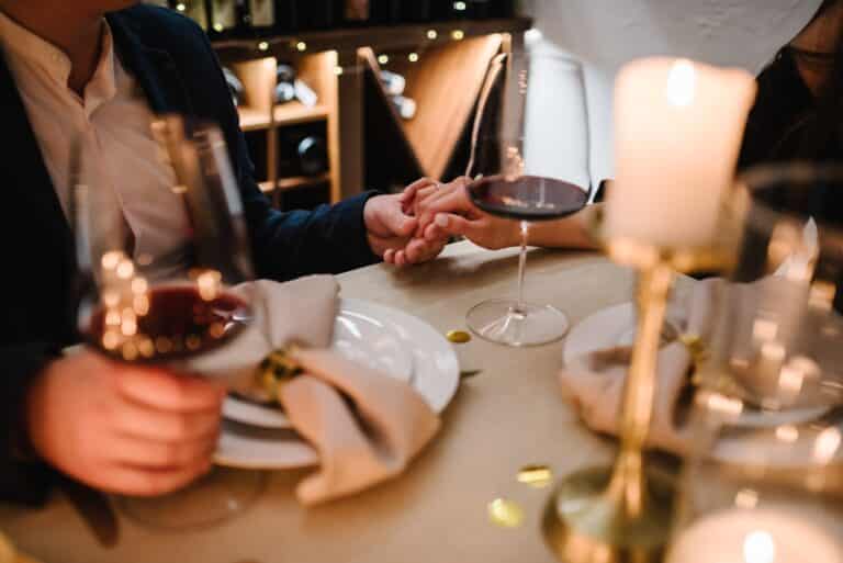 A couple holds hands as they share a candlelit meal on their secluded romantic getaways in Missouri.