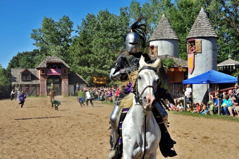 A knight in armor riding white horse at the Renaissance Fair in Kansas City.